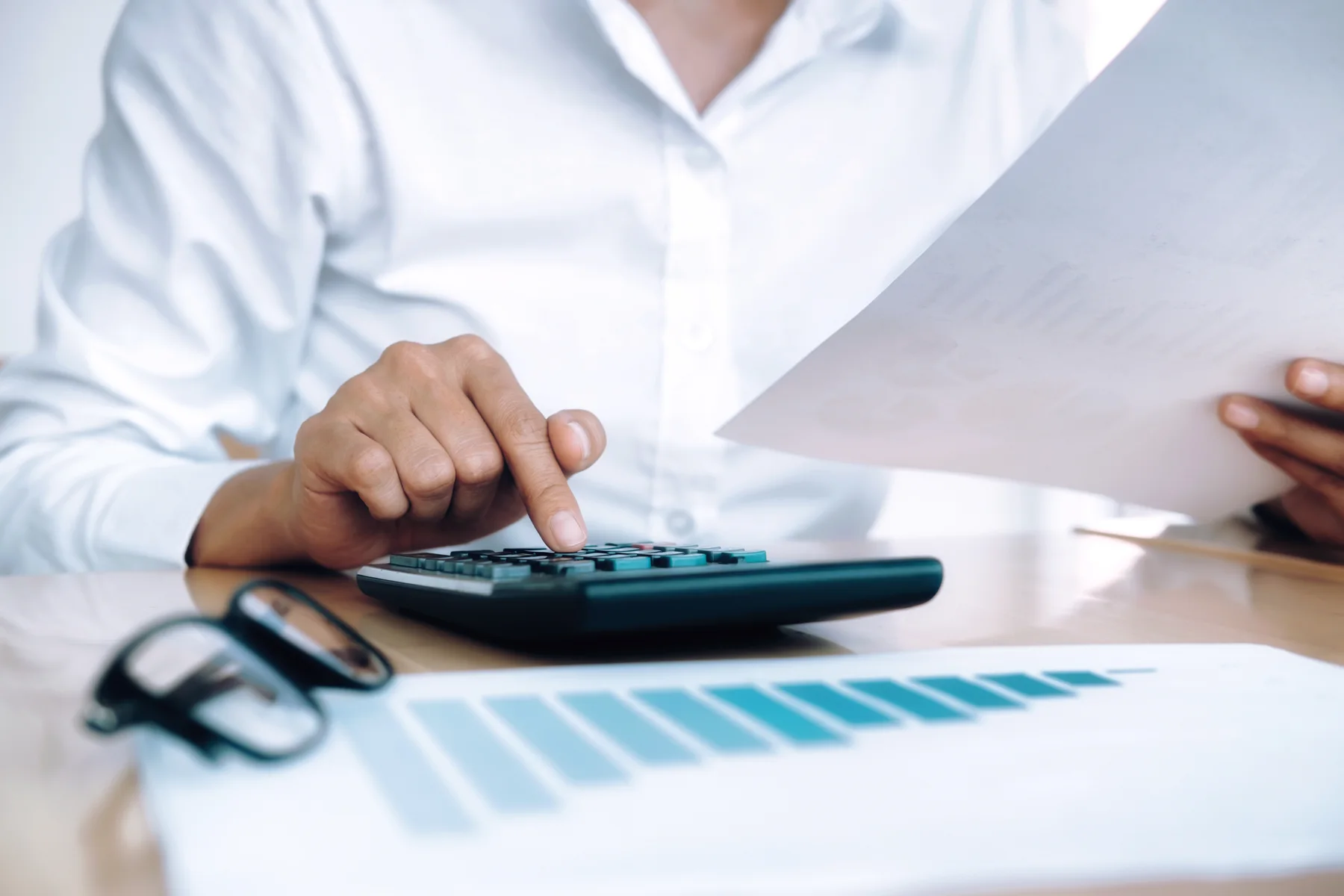 Hands with a document and a calculator.